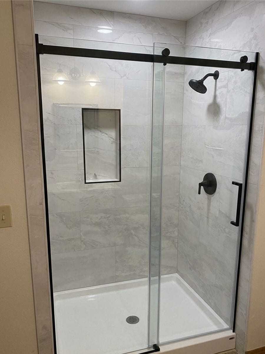 The same bathroom rendered by the Key Visualizer with Roman Marble wall panels, a black frameless sliding glass door, recessed niche, and matte black fixtures